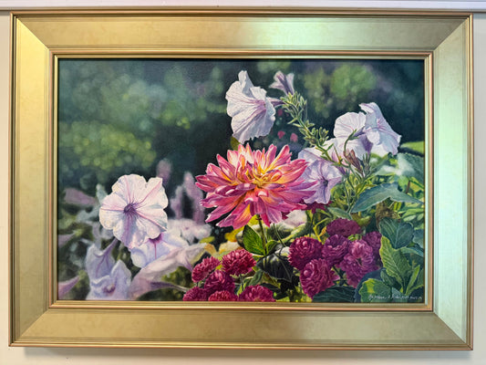 A framed floral painting featuring a central pink dahlia surrounded by light purple, magenta, and green foliage, set in a wide gold frame against a white wall.